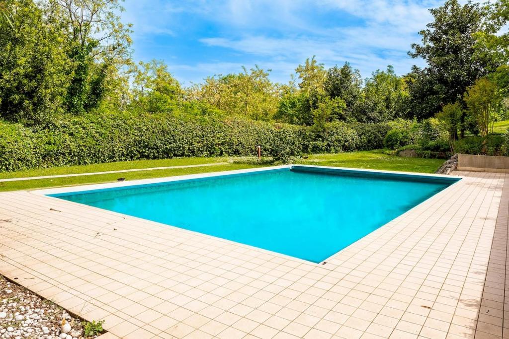 - une piscine dans l'arrière-cour dotée de carrelage dans l'établissement Villa Essenza, à Barcuzzi