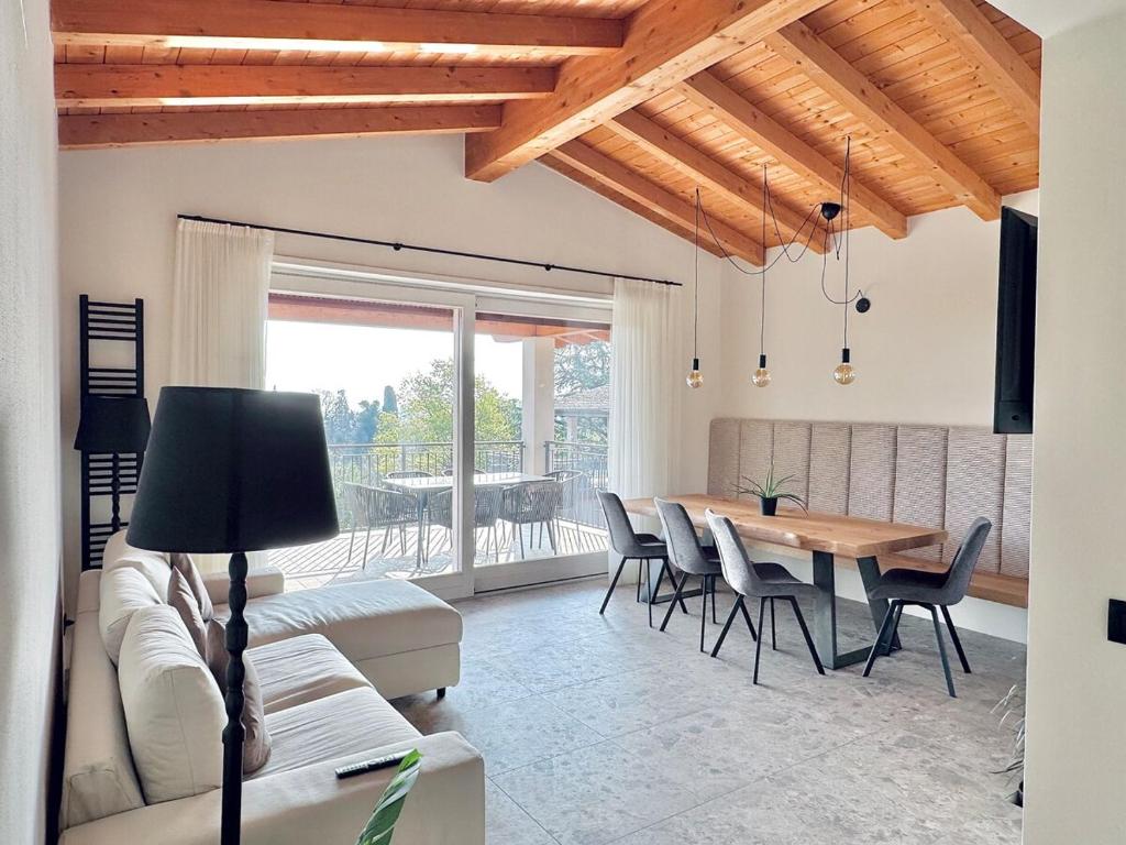 un salon avec un canapé, une table et des chaises dans l'établissement Villa Essenza, à Barcuzzi