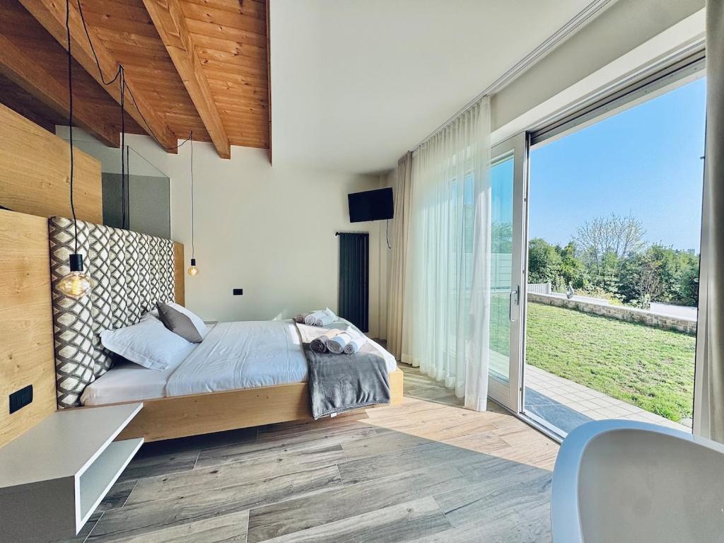 une chambre avec un lit et une grande fenêtre dans l'établissement Villa Essenza, à Barcuzzi 58 autres photos