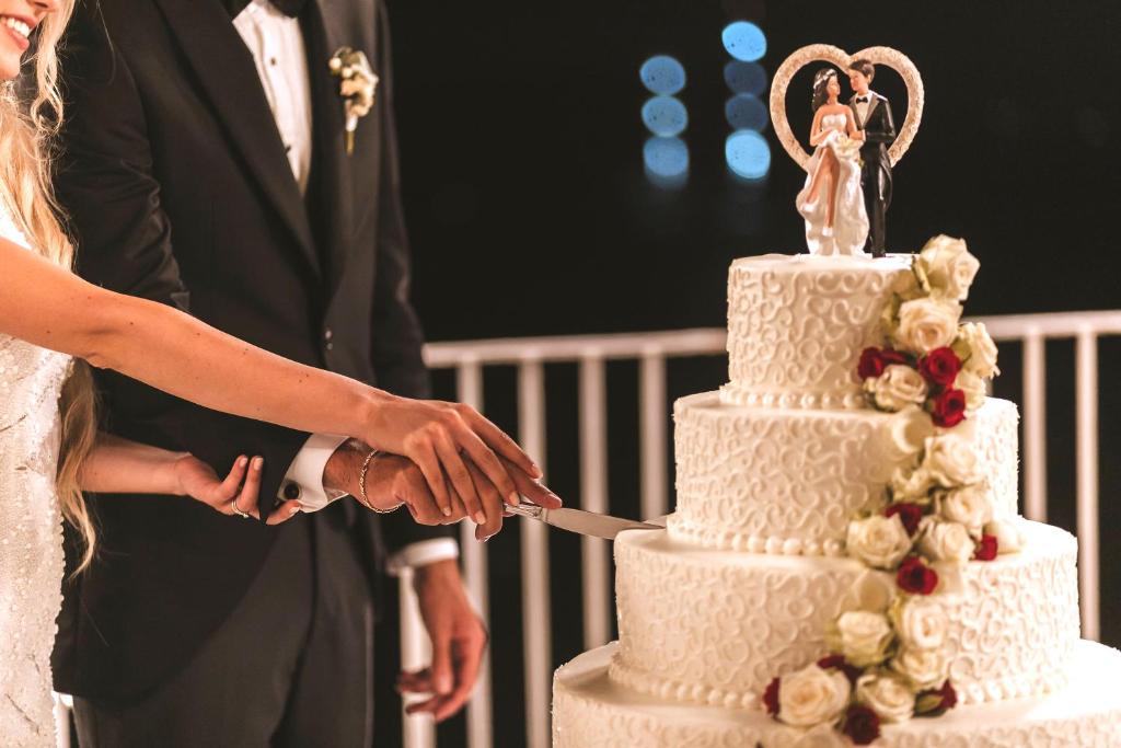 les mariés coupant leur gâteau de mariage dans l'établissement Strand Hotel Delfini, à Ischia 110 autres photos
