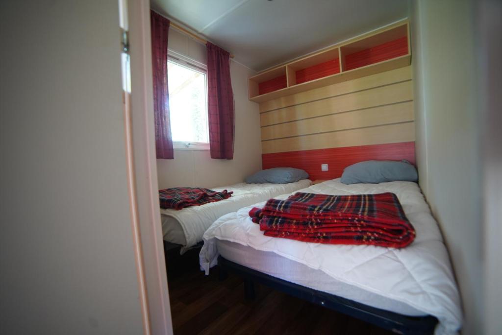 une chambre avec deux lits et une fenêtre dans l'établissement Mobil-home Saint-Chéron 91530 Camping Parc des roches, à Mirgaudon