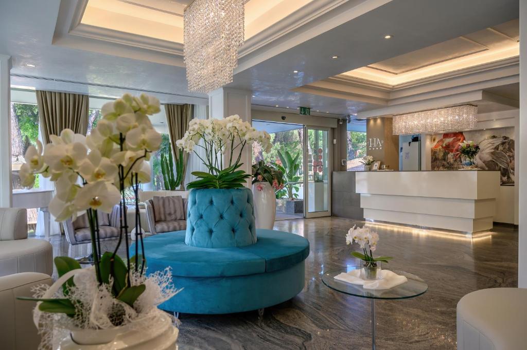 un hall d'entrée avec un pouf bleu avec des fleurs dedans dans l'établissement Hotel Alexander, à Milano Marittima