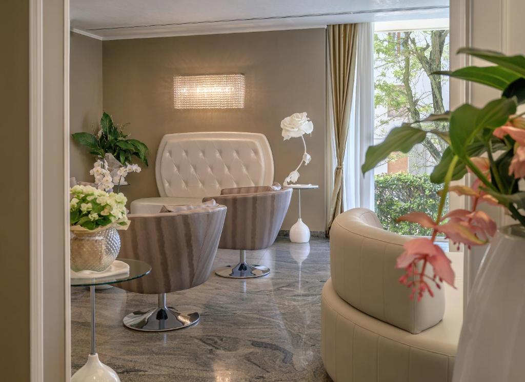 un salon avec une chaise et des plantes dans l'établissement Hotel Alexander, à Milano Marittima