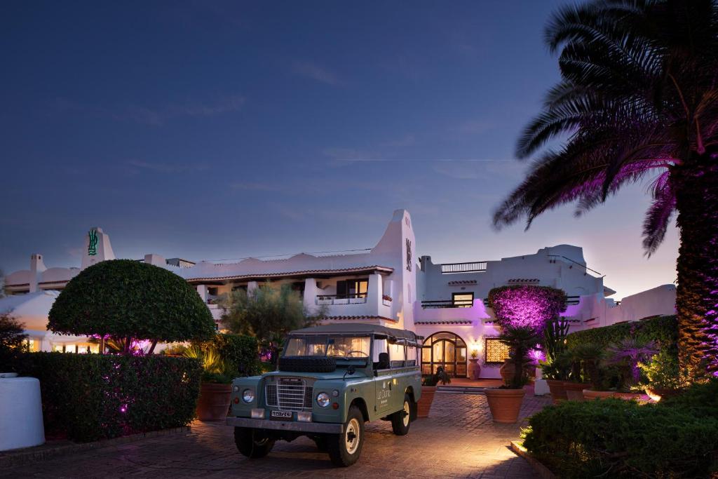 une jeep verte garée devant un bâtiment dans l'établissement Hotel Le Dune, à Sabaudia