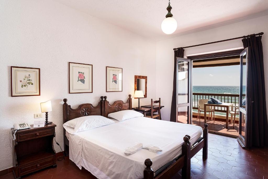une chambre avec un lit et un balcon avec l'océan dans l'établissement Hotel Le Dune, à Sabaudia