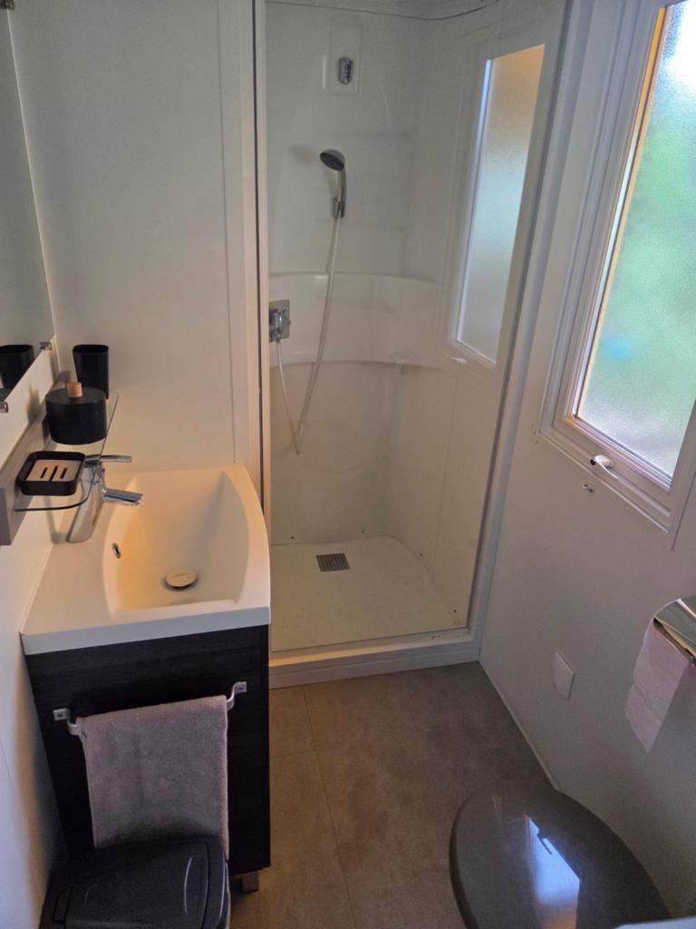 une salle de bain avec douche et lavabo dans l'établissement Fabuleux mobil-homme 4/6 personnes, à Fréjus