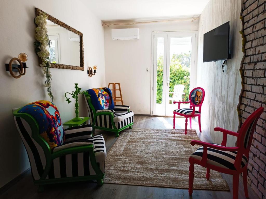 - un salon avec des chaises colorées et une télévision dans l'établissement Hemingway Villa-refurbished 2025, à Specchiolla