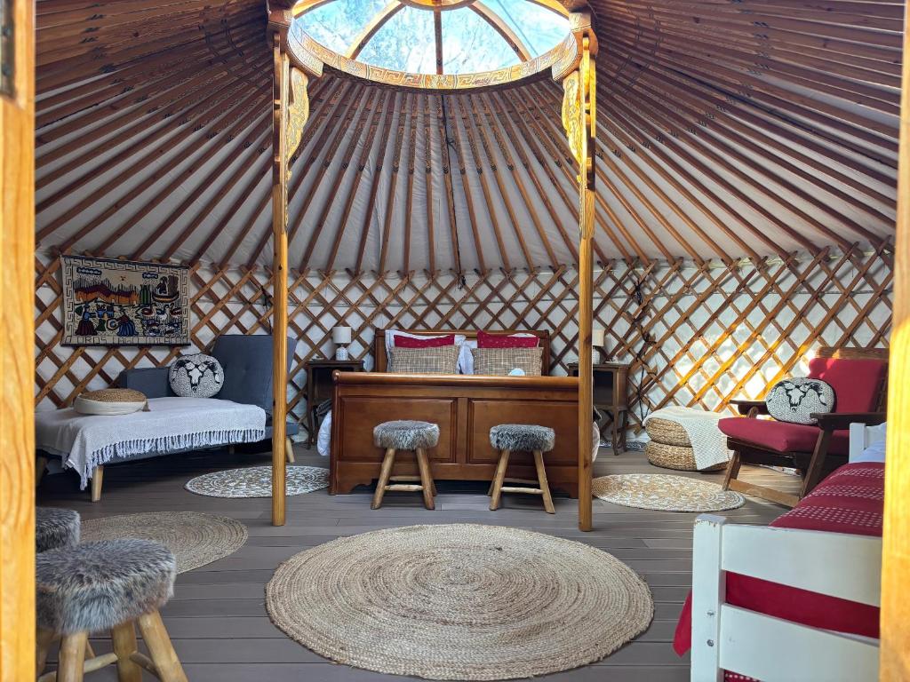 Cette chambre comprend une yourte avec un bureau et des chaises. dans l'établissement Yourte mongole, à Champfromier