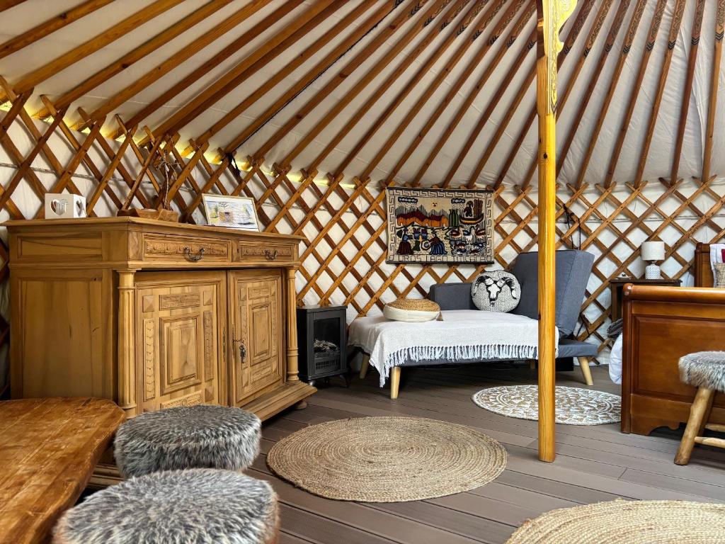 une yourte avec un lit et des chaises dans une chambre dans l'établissement Yourte mongole, à Champfromier