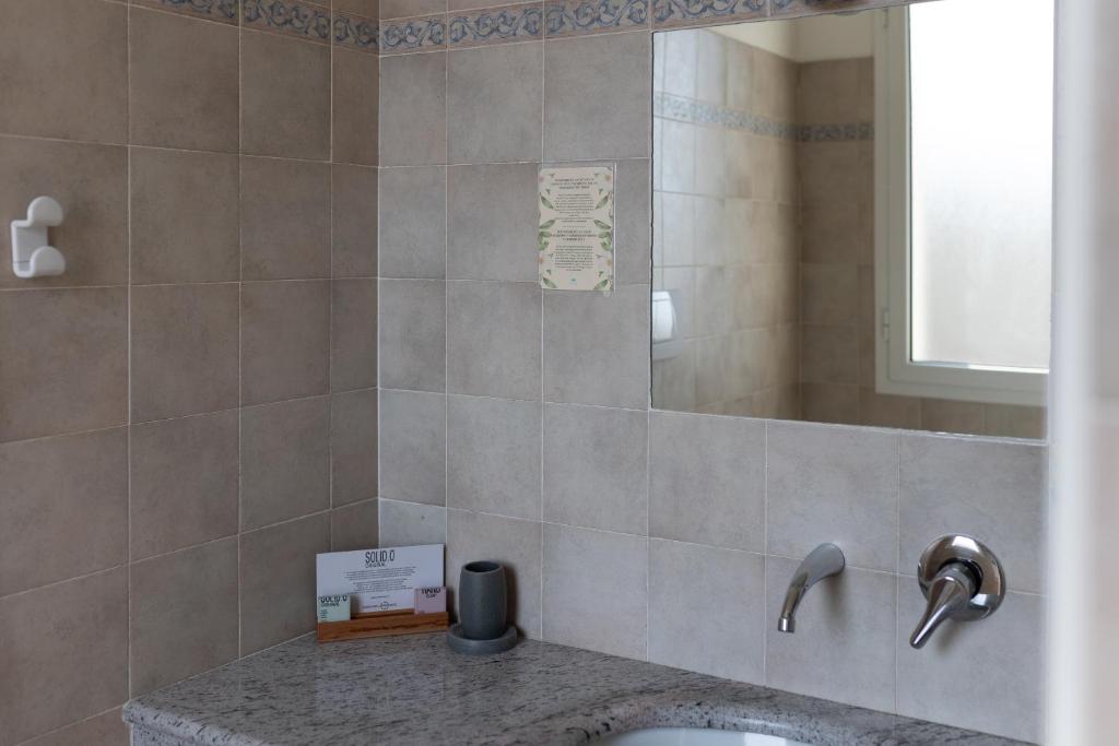 une salle de bain avec un lavabo et un miroir dans l'établissement Hotel La Gioiosa, à Finale Ligure