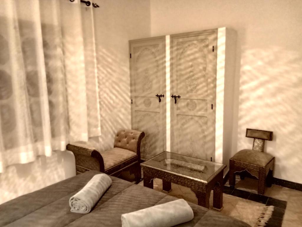 une chambre avec un lit, une chaise et une table dans l'établissement Riad Orient Palace, à Marrakech 37 autres photos