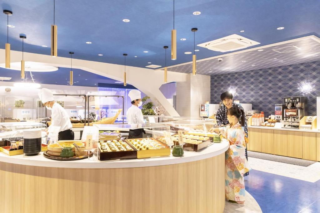 un groupe de personnes dans une cuisine préparant la nourriture dans l'établissement Ooedo Onsen Monogatari Premium Toba Saichoraku, à Toba