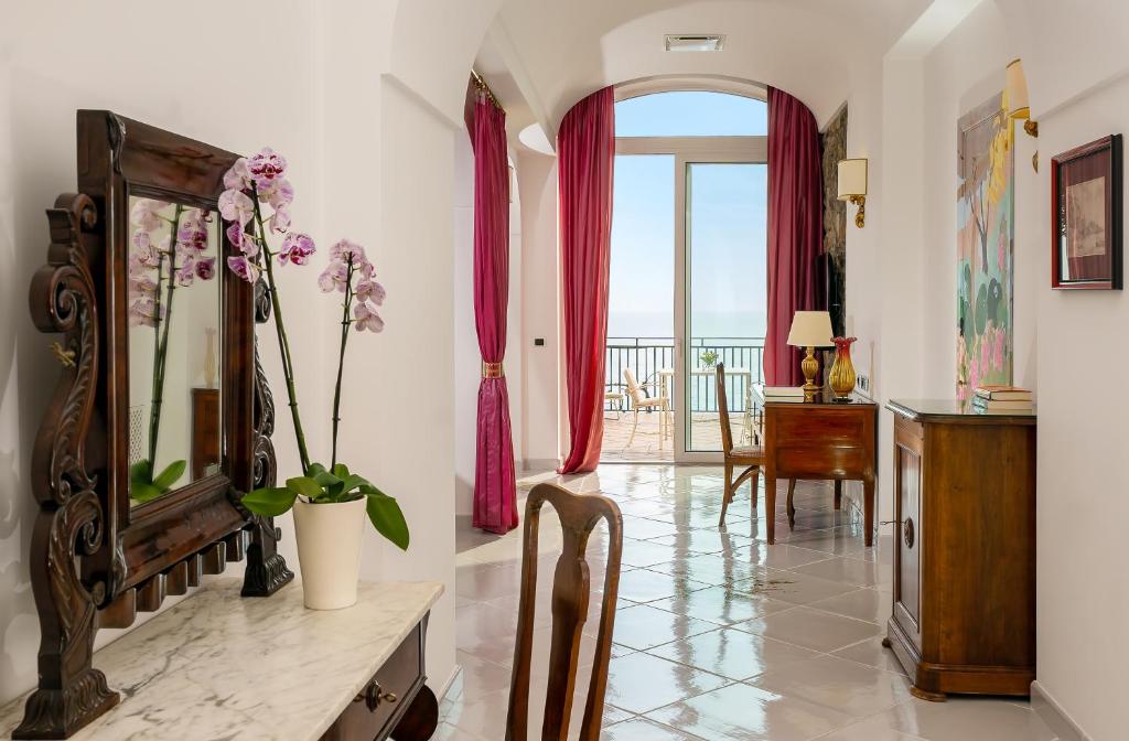un salon avec un miroir et une table avec un bureau dans l'établissement Hotel Santa Caterina, à Amalfi