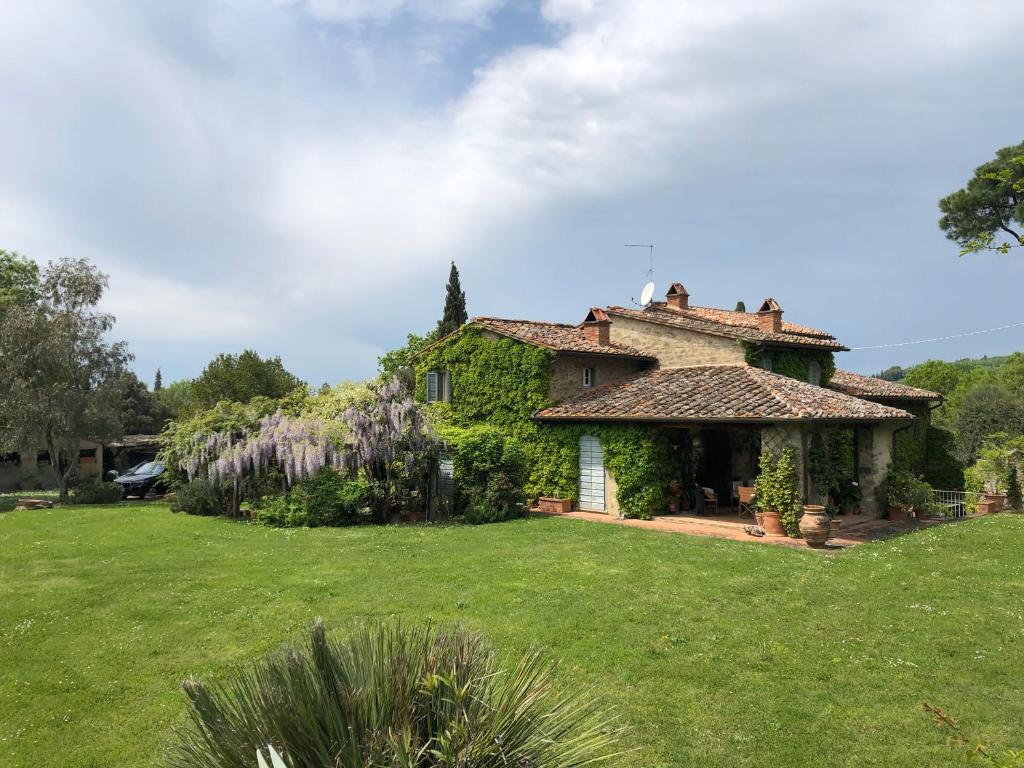 une grande maison avec une cour en gazon devant elle dans l'établissement Villa Elena Tuscany - Pool & Garden Arezzo - IHH, à Vitiano