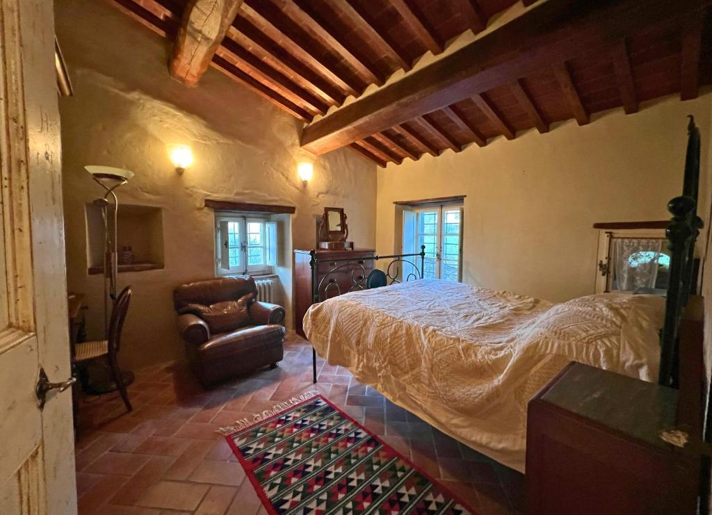 une chambre avec un grand lit et une chaise dans l'établissement Villa Elena Tuscany - Pool & Garden Arezzo - IHH, à Vitiano 154 autres photos