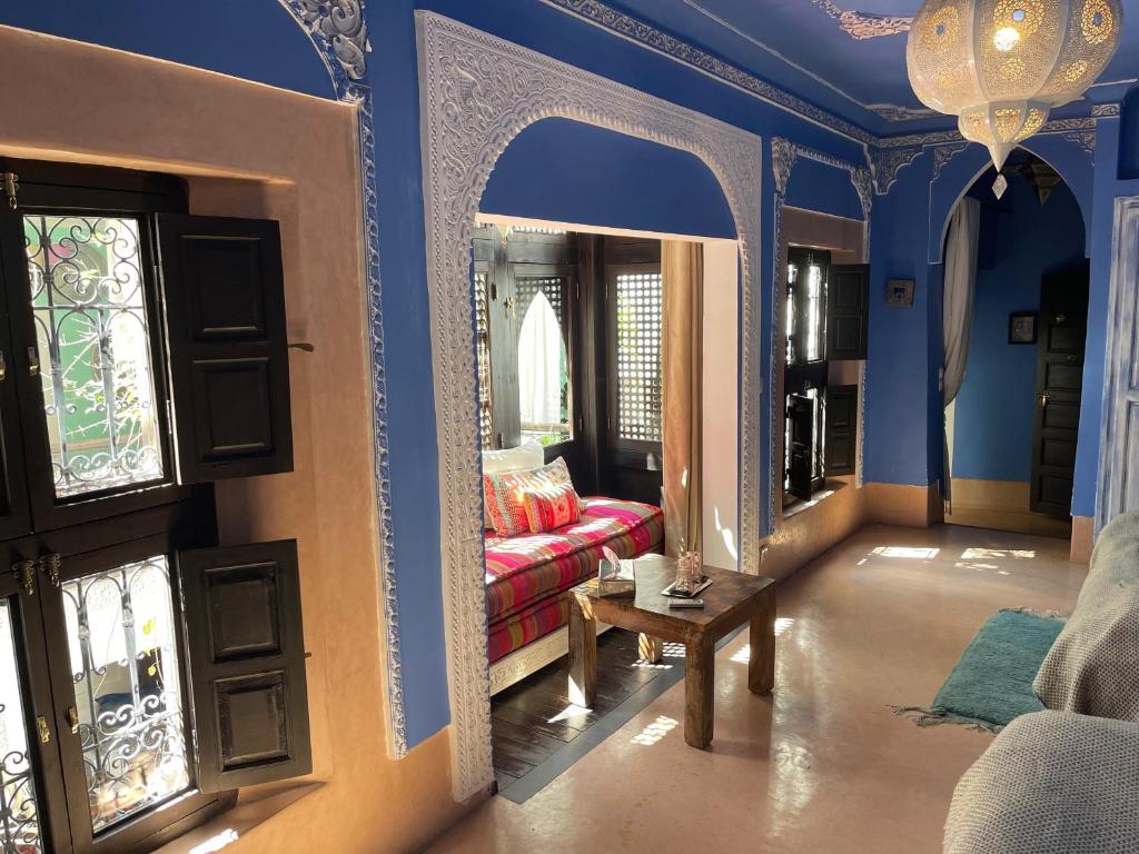 - un salon avec des murs bleus et un canapé rouge dans l'établissement Riad Chocolat, à Marrakech