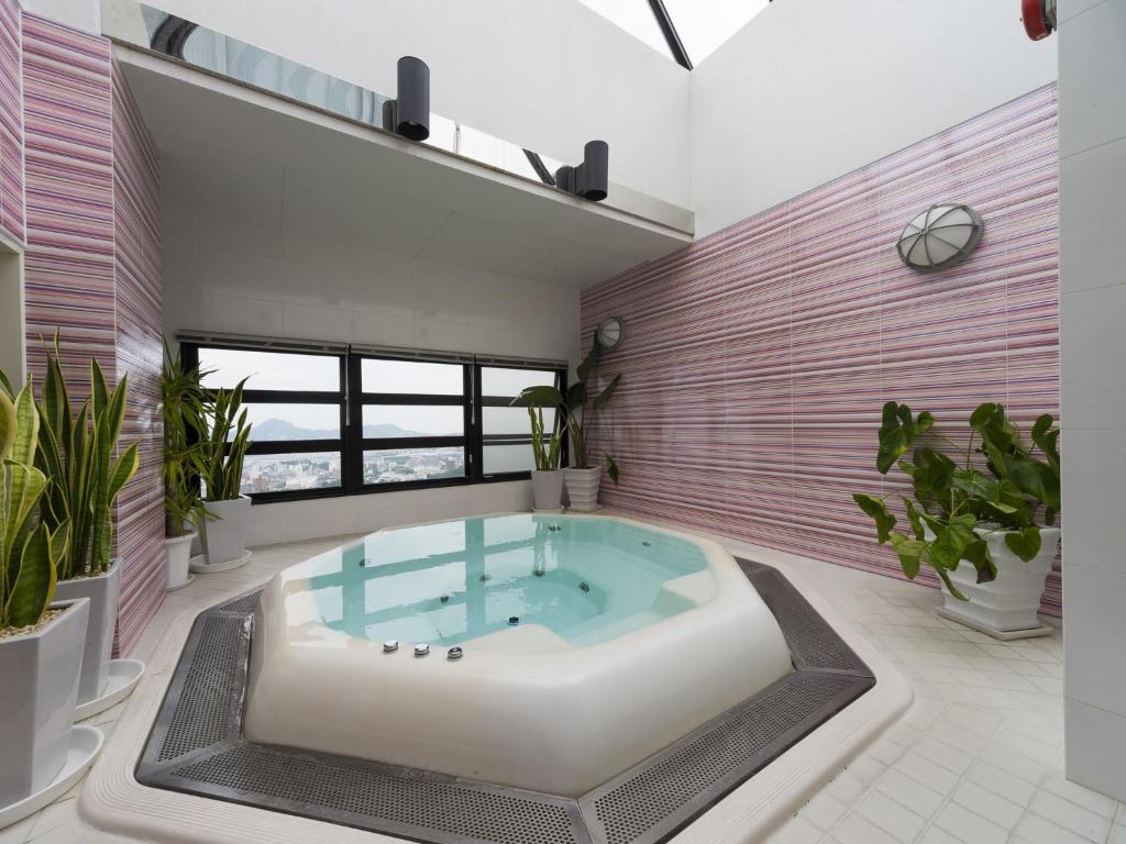 - un bain à remous dans une pièce ornée de plantes dans l'établissement リゾートホテル CARA -Adult Only-, à Sasebo