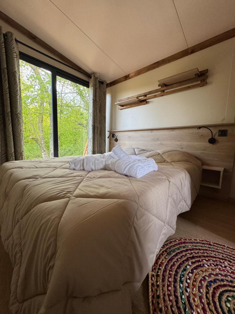 une chambre avec un grand lit avec une fenêtre dans l'établissement La Buissonnière Lodges, à Chisseaux 37 autres photos