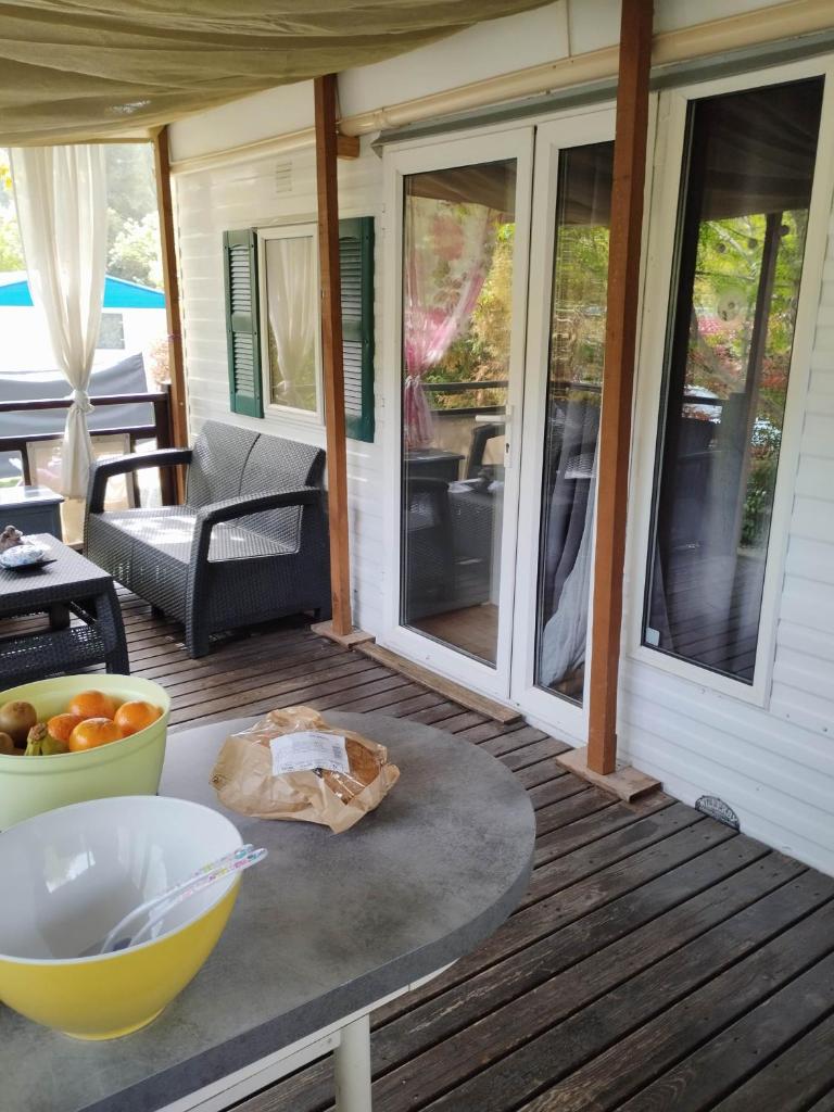 - une terrasse couverte avec une table et un bol de fruits dans l'établissement Mobil home Var, à Méounes-lès-Montrieux
