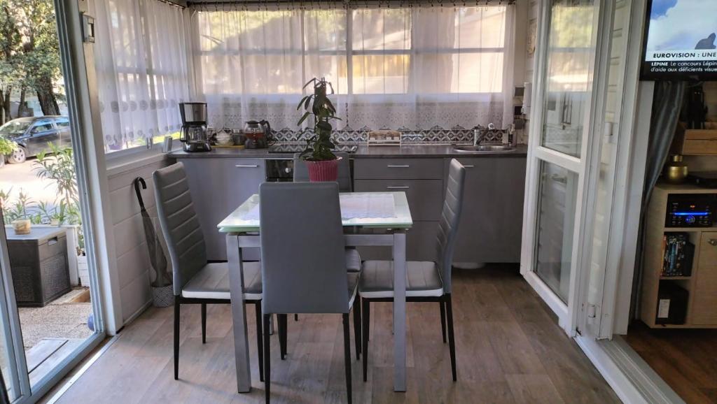 une cuisine avec une table et des chaises et une cuisine avec des fenêtres dans l'établissement Camping L'Oasis 5 étoiles à Puget-sur-Argens, à Puget-sur Argens