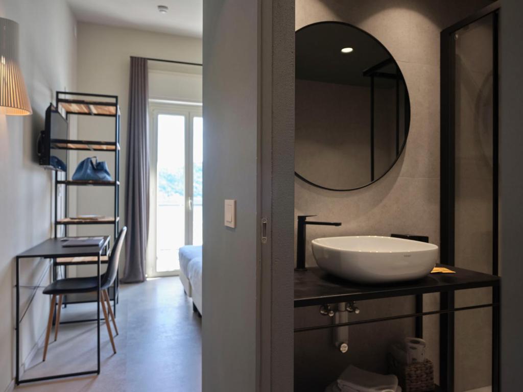 une salle de bain avec un lavabo et un miroir sur un comptoir dans l'établissement Hotel Carillon, à Baveno 129 autres photos