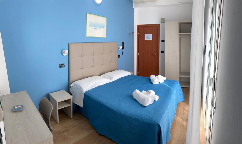 - une chambre bleue dotée d'un lit avec deux ours en peluche dans l'établissement Hotel Stella Alpina, à Rimini