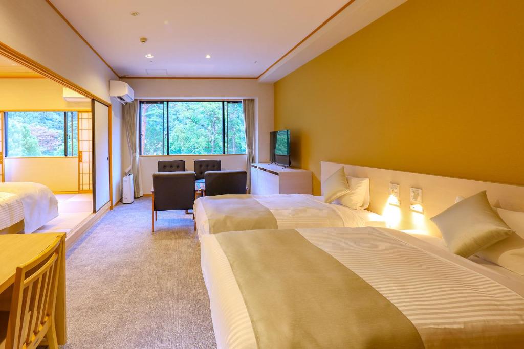 une chambre d'hôtel avec deux lits et un bureau dans l'établissement TAOYA Nasu Shiobara, à Nasushiobara