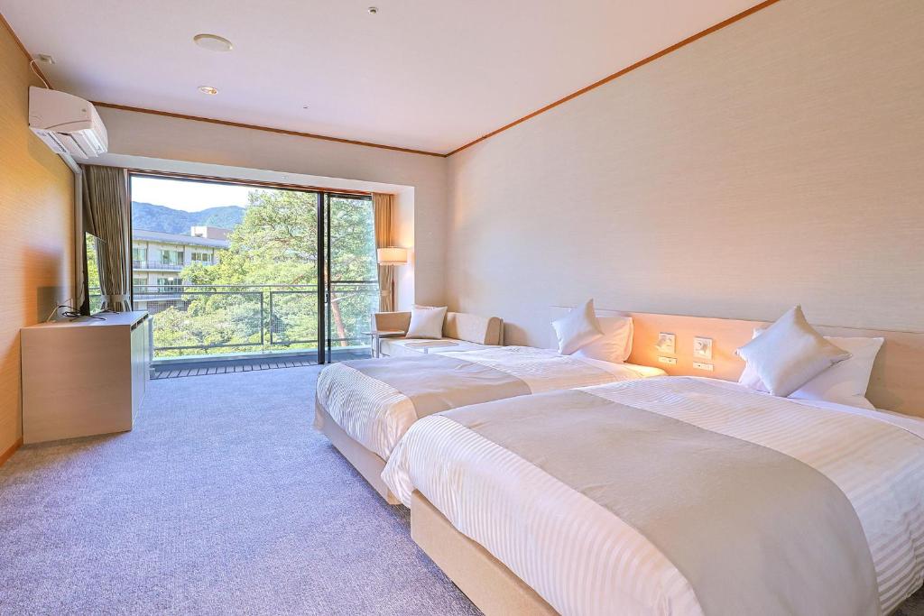 une chambre d'hôtel avec deux lits et une grande fenêtre dans l'établissement TAOYA Nasu Shiobara, à Nasushiobara