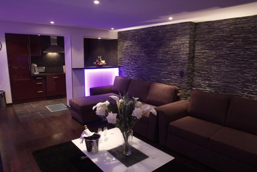 un salon avec un canapé et une table avec des fleurs dans l'établissement Residence Aqualiva à Valberg Piscine privative dans chacun des appartements situé à 20 m des pistes de ski, à Valberg