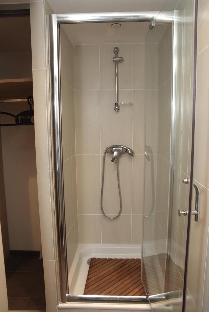 une cabine de douche avec un pommeau de douche et une douche. dans l'établissement Residence Aqualiva à Valberg Piscine privative dans chacun des appartements situé à 20 m des pistes de ski, à Valberg