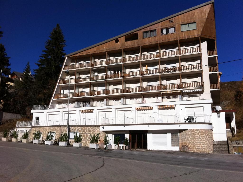 un grand bâtiment blanc avec des balcons sur une rue dans l'établissement Residence Aqualiva à Valberg Piscine privative dans chacun des appartements situé à 20 m des pistes de ski, à Valberg