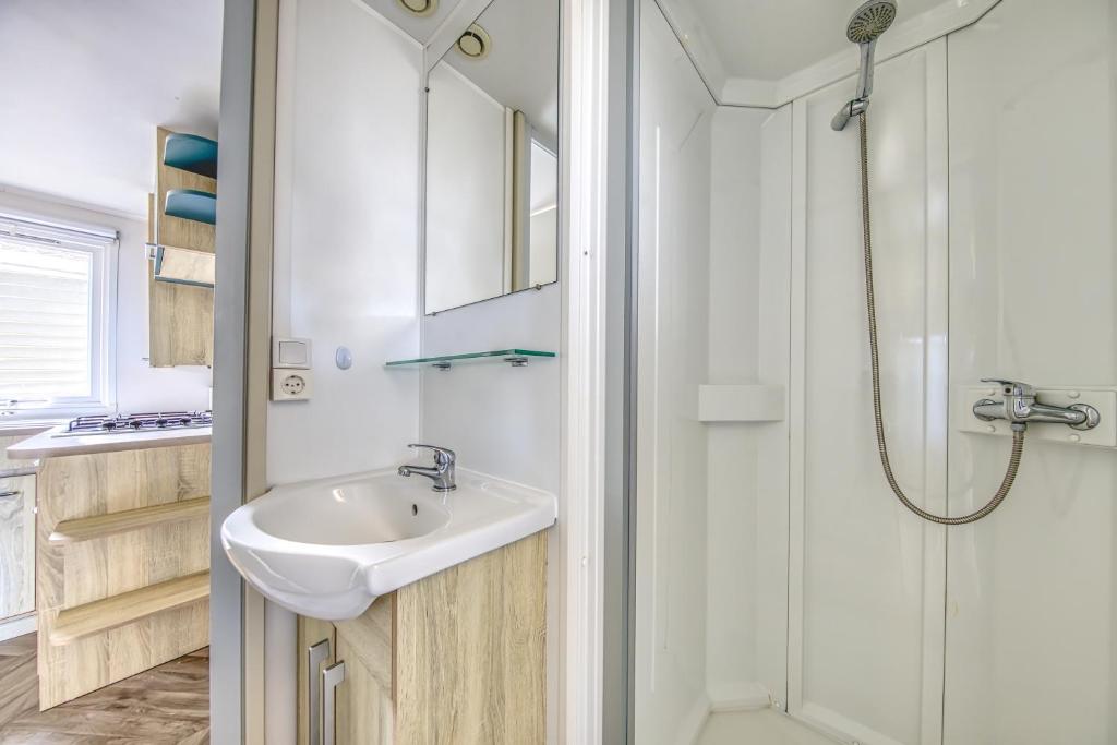 une salle de bain avec un lavabo et une douche dans l'établissement Mobilhome Camping Siblu les Viviers, à Lège-Cap-Ferret