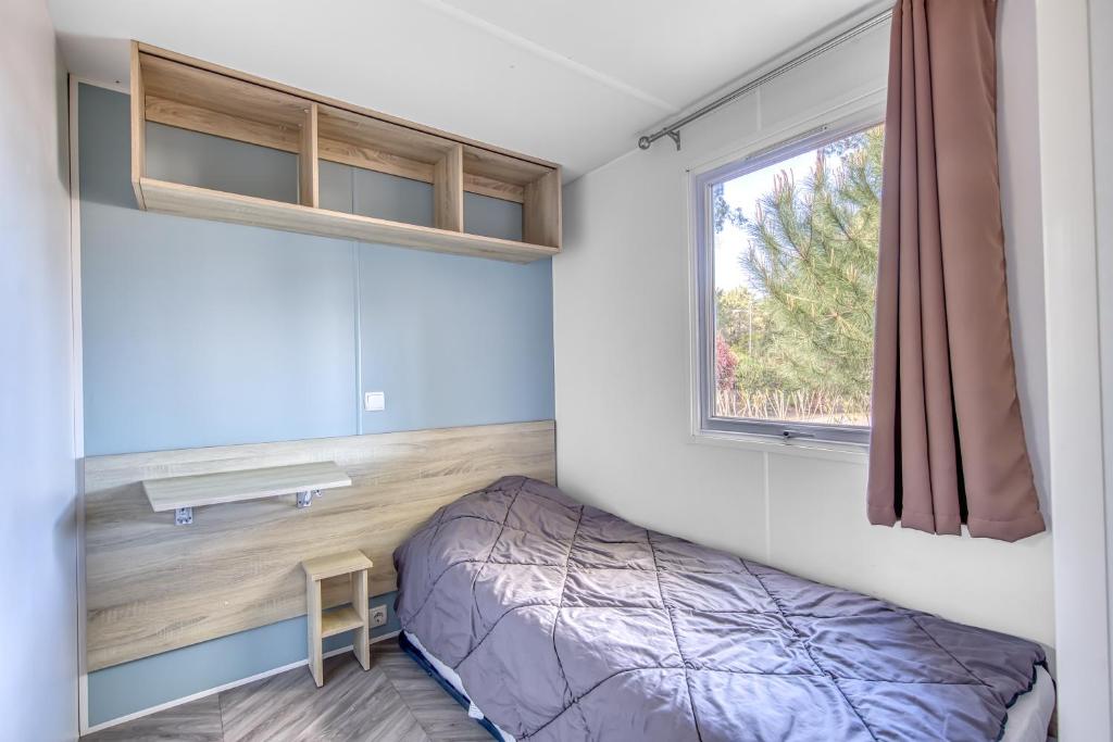 une chambre avec un lit et une fenêtre dans l'établissement Mobilhome Camping Siblu les Viviers, à Lège-Cap-Ferret