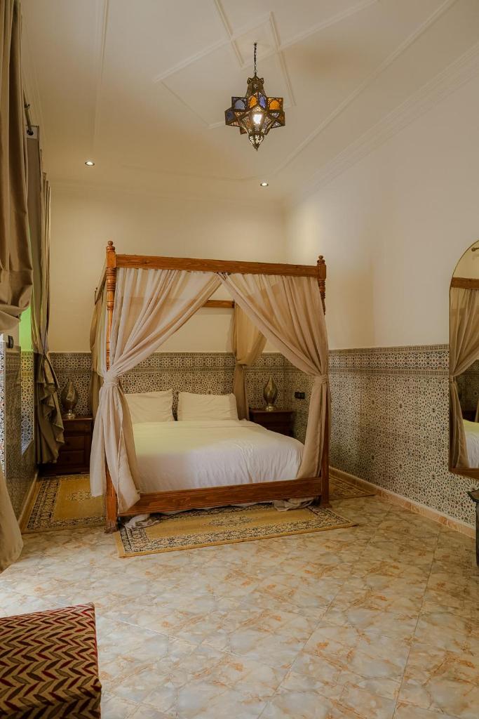 une chambre avec un lit à baldaquin dans l'établissement Riad Dar Al Fassia, à Oujda