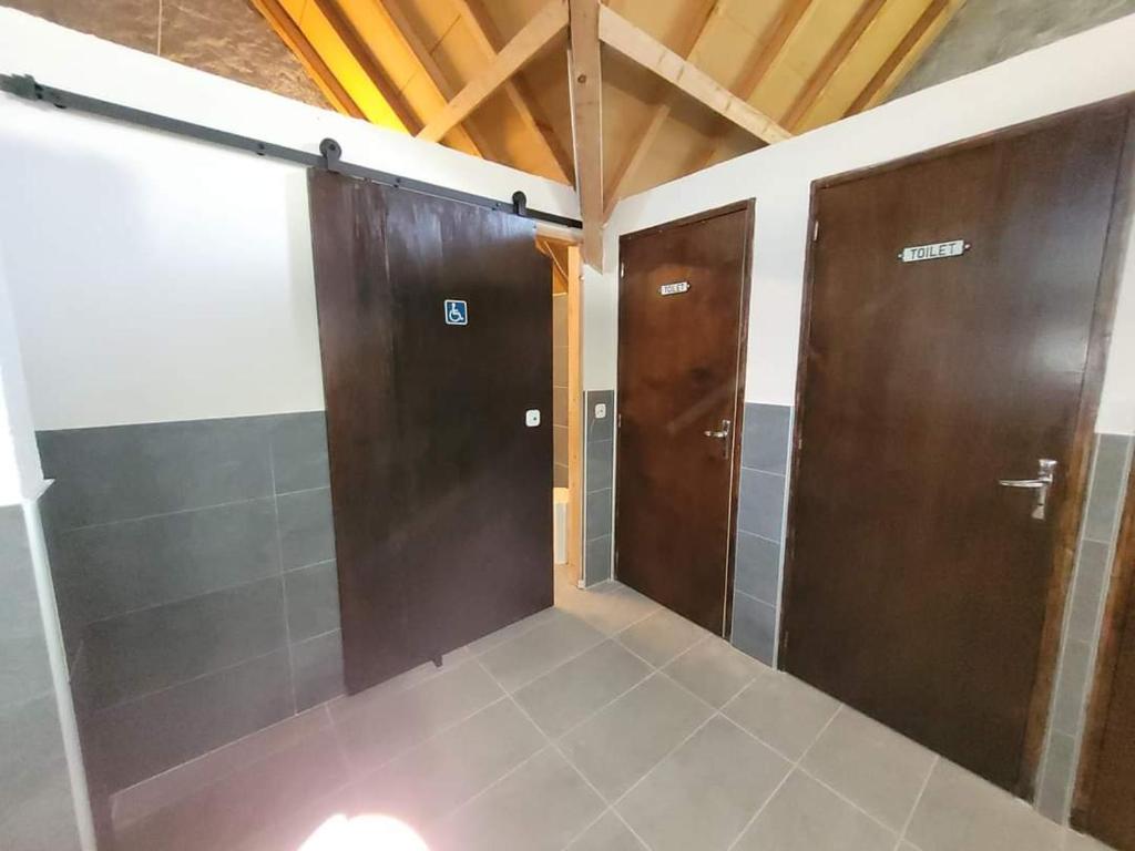 - une salle de bains avec deux portes et du carrelage dans l'établissement TIPIsche trekkershut - Camping Le Soustran, à Neuvic 17 autres photos