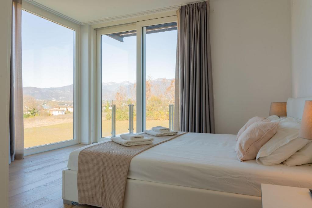 une chambre avec un lit et une grande fenêtre dans l'établissement Villa Petra with a pool, à Manerba del Garda