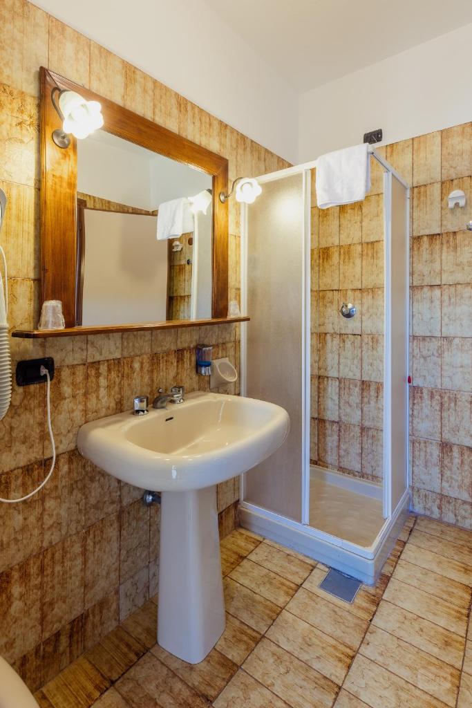 une salle de bain avec un lavabo et une douche dans l'établissement Hotel Malaspina, à Bosa Marina 13 autres photos