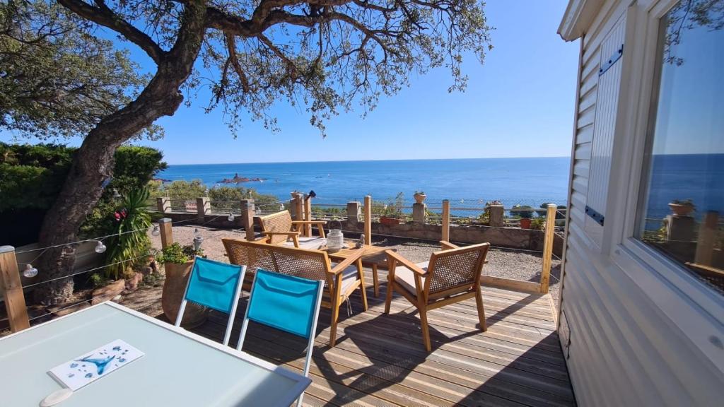 - une table et des chaises sur une terrasse avec vue sur l'océan dans l'établissement Paradis bleu et ile d'or, à Saint-Raphaël