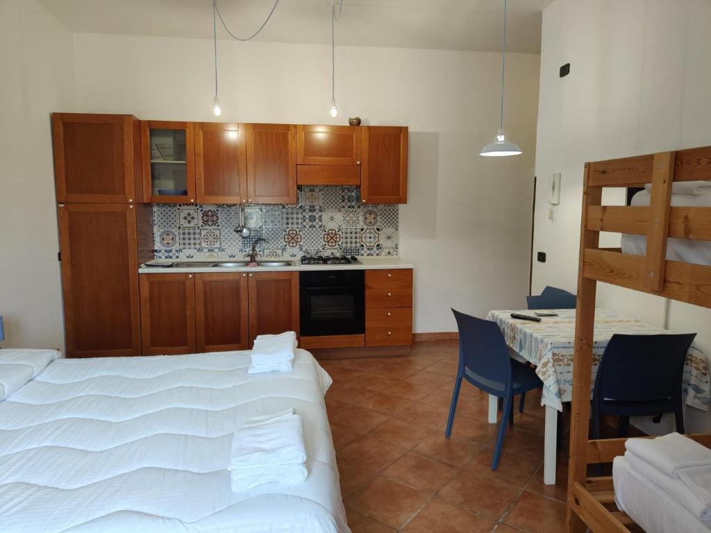 une chambre avec un lit et une cuisine avec une table dans l'établissement That's Amore Cilento Country House, à Agnone