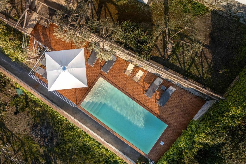 - une vue sur la piscine avec un parasol et des chaises dans l'établissement Villa Dafne Gulf Views Pool and Guest Services by Feeling Italy, à Massa Lubrense