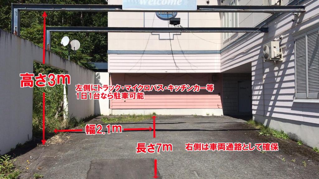 un garage avec une écriture sur le côté d'un bâtiment dans l'établissement Hotel Tiffany (Adult Only), à Asahikawa