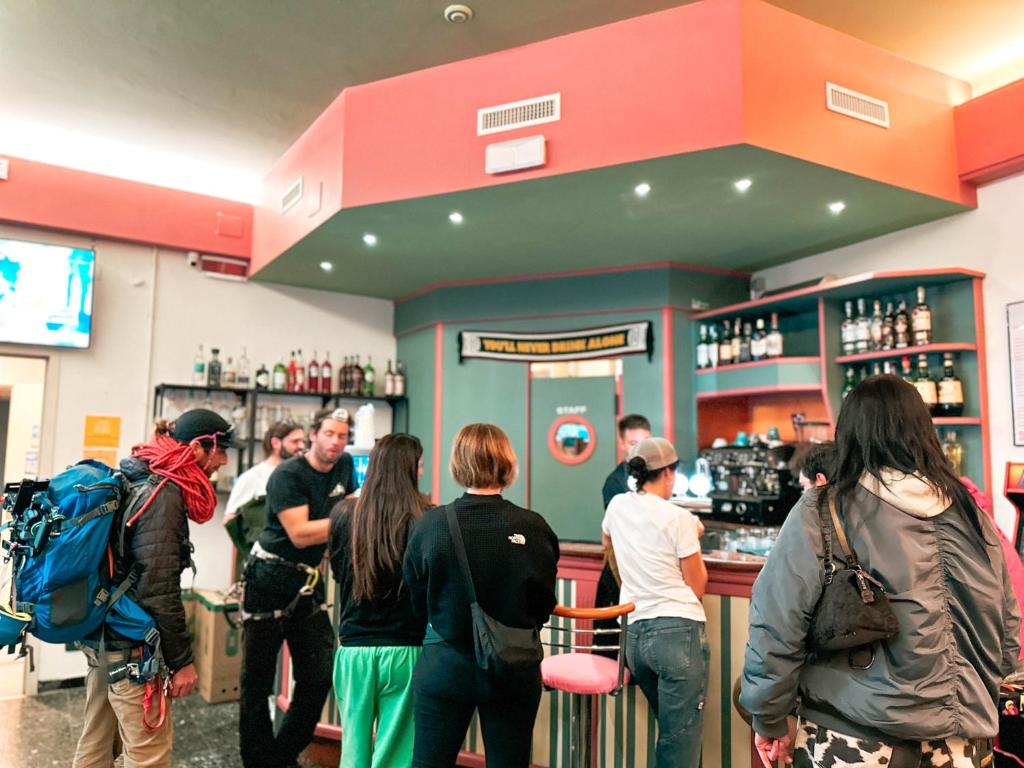 un groupe de personnes debout autour d'un bar dans l'établissement Hotel Bello by Ostello Bello, à Finale Ligure