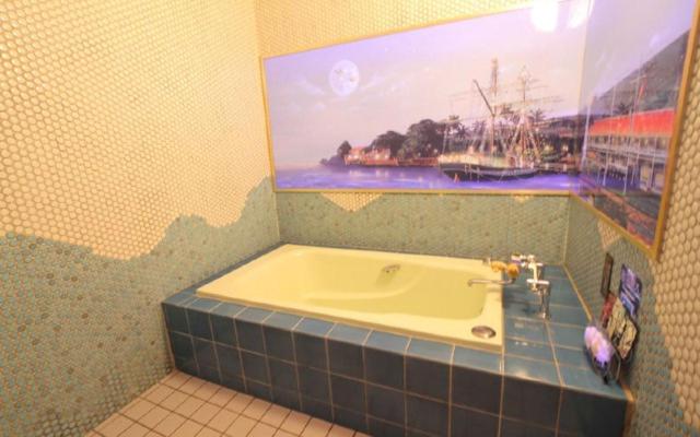 La salle de bains est pourvue d'une baignoire avec une photo murale. dans l'établissement hotel surfrider, à Wada-shinden