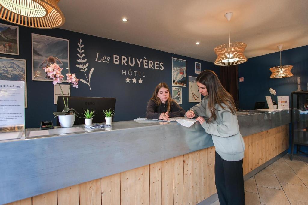 Deux femmes debout au comptoir d'un restaurant dans l'établissement Hôtel Les Menuires Les Bruyères, aux Menuires