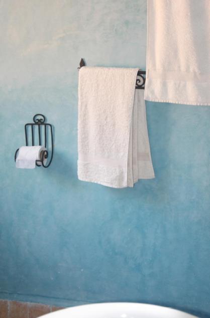 une salle de bain avec une serviette blanche accrochée à un mur bleu dans l'établissement Dar Rass El Maa, à Chefchaouen