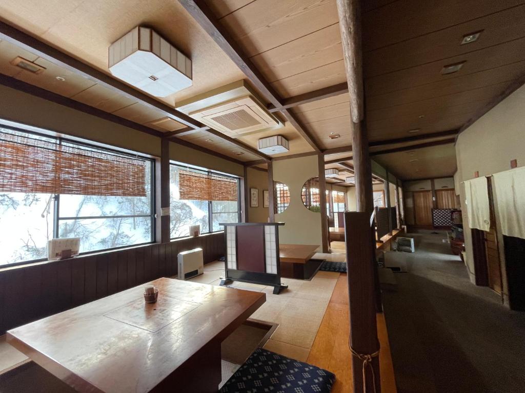 une pièce avec une table en bois et quelques fenêtres dans l'établissement 銭がめ, à Kanazawa
