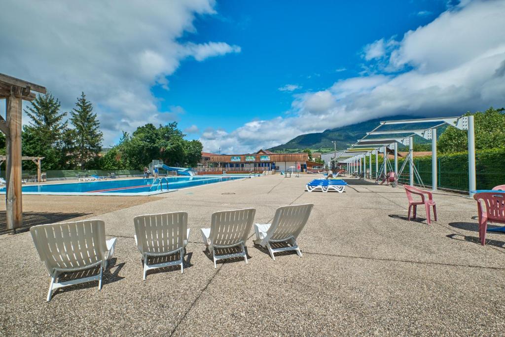 - un groupe de chaises assises à côté d'une piscine dans l'établissement Mobil Home 6 personnes 206, à Mens