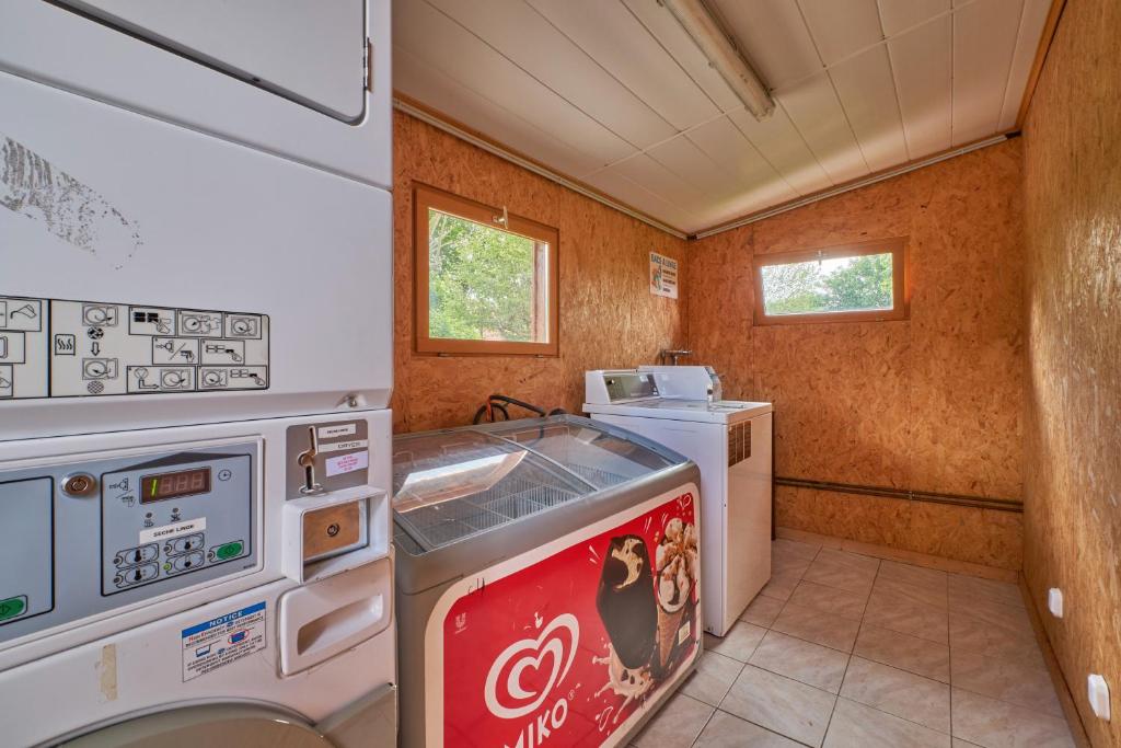 une petite cuisine avec une machine à coca et une cuisinière dans l'établissement Mobil Home 6 personnes 206, à Mens