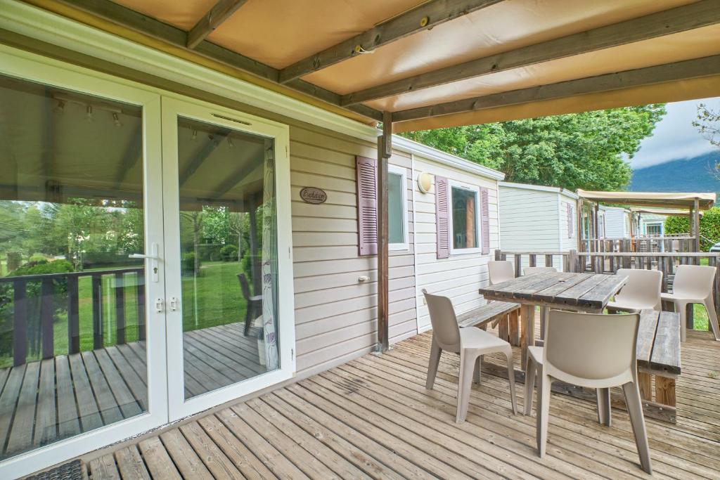 un patio avec une table et des chaises sur une terrasse dans l'établissement Mobil Home 6 personnes 206, à Mens