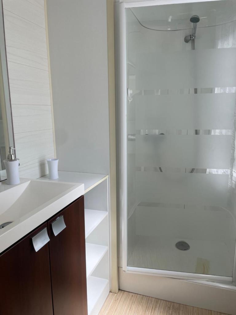 une salle de bain avec une douche en verre et un lavabo dans l'établissement Mobil home chez Sophie, à Hourtin 15 autres photos